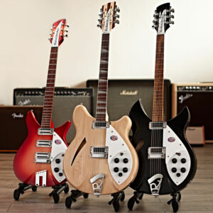 Three Rickenbacker guitars stood in front of Fender and Marshall amps